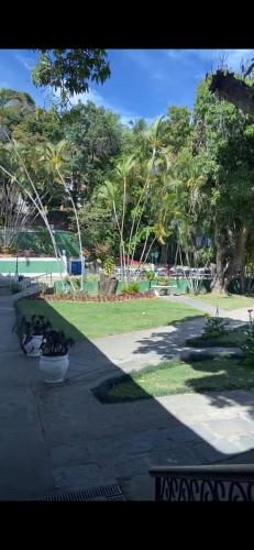 a park with trees and grass and a sidewalk at Mara Palace Hotel in Vassouras