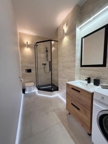 ワルシャワにあるLeśny apartament z ogrodemのシャワーと洗面台付きのバスルーム