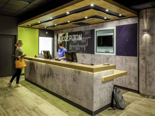 a woman standing in front of a reception desk at ibis budget Nürnberg City Messe in Nürnberg