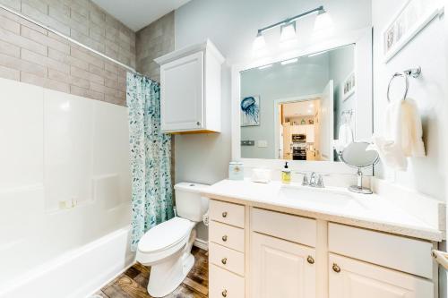 a bathroom with a sink and a toilet and a mirror at Amazing Gulf Views Large Deck Family Fun in Hercules Offshore Heliport