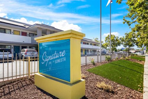 a blue and yellow sign in front of a building at Signature Inn San Jose in San Jose