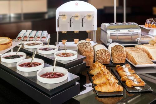 a buffet with different types of bread and pastries at NH Dresden Neustadt in Dresden