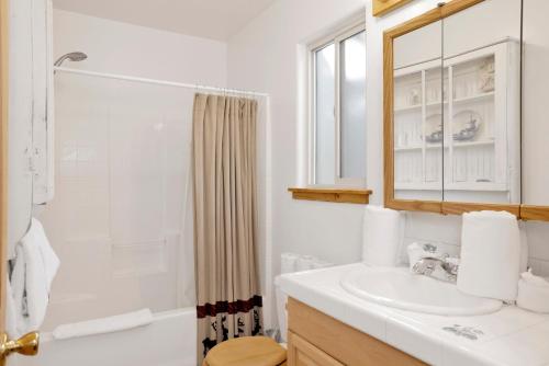 ein weißes Badezimmer mit Waschbecken und Dusche in der Unterkunft River rock lodge #1953 in Big Bear Lake