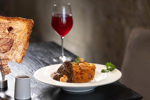 卡哈马卡Wyndham Costa del Sol Cajamarca的桌上的一小块食物,加上一杯葡萄酒