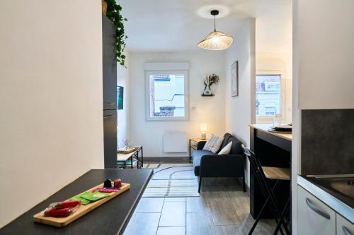 a kitchen and a living room with a table at L'Odyssée - Gare - Wifi - Netflix in Tourcoing