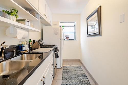 a kitchen with a sink and a white refrigerator at Amazing location, Unique Oceanfront Beach House! in Manhattan Beach