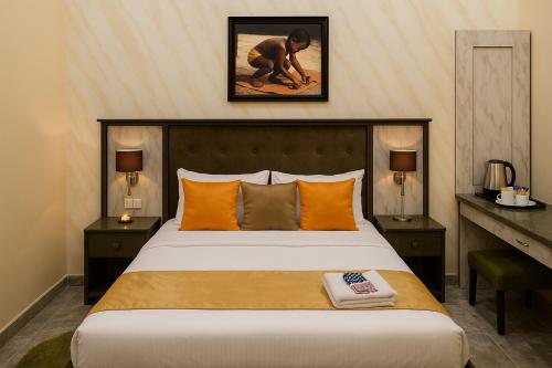 a bedroom with a large bed with orange pillows at De-Manna Ota in Otta