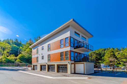 an apartment building with a balcony on a street at Serenity at Deerhaven #A in Gold Beach