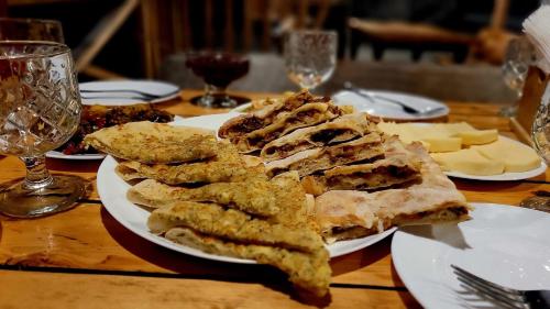 a table with plates of food on top at Heshkili huts and cabins Svaneti in Keshkili