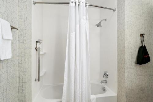 a bathroom with a shower with a white shower curtain at Holiday Inn Express & Suites - Detroit Northwest - Livonia by IHG in Livonia