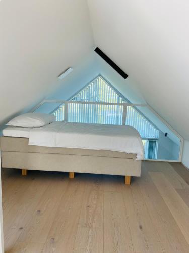 ein Schlafzimmer mit einem Bett im Dachgeschoss in der Unterkunft Domein Mase - Luxe vakantiewoningen aan de Maas in Maaseik in Maaseik