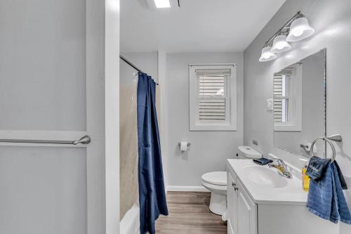 a bathroom with a blue shower curtain and a sink at Pitcher's Paradise Apt 1-All Star Baseball Rentals in Oneonta