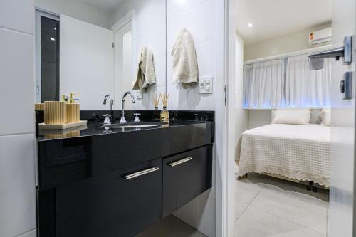 a bathroom with a sink and a bed in a room at Live a dream in the heart of LEBLON in Rio de Janeiro