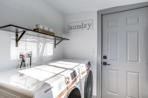 a laundry room with a washing machine and a door at Prescott Retreat with Hot Tub about 3 Mi to Dtwn! in Prescott