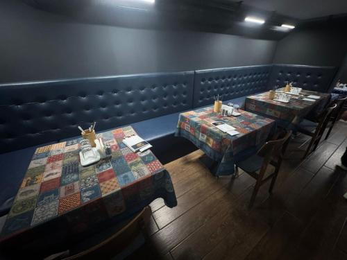 a restaurant with two tables and chairs in a room at Hotel Corner Batumi in Batumi