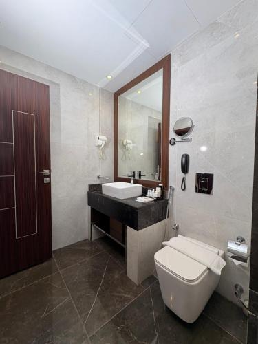 a bathroom with a toilet and a sink and a mirror at mawasim al hay at hotel in Jeddah