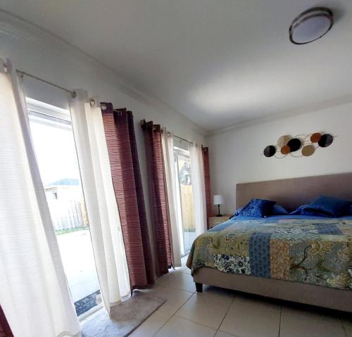 a bedroom with a bed and windows with a view at Super Room 5 minutes from PBI Airport in West Palm Beach