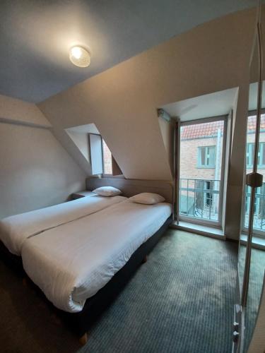 a bedroom with two beds and a large window at Koffieboontje Budget in Bruges