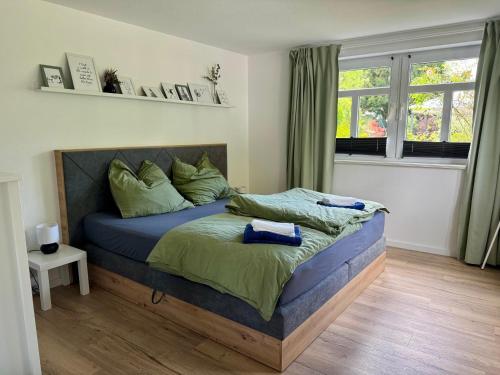 a bedroom with a bed with blue sheets and a window at Ferienwohnung Belina im Thüringer Wald in Tabarz