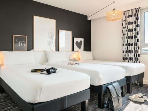 two beds in a room with black walls at ibis Styles Paris Gare de l'Est Château Landon in Paris