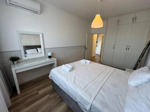 a bedroom with a white bed and a mirror at Caesar Resort Spa Long Beach 