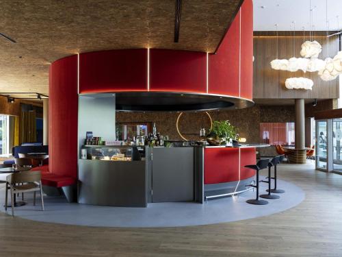 a kitchen with red cabinets and a bar with chairs at Novotel Zurich City West in Zürich