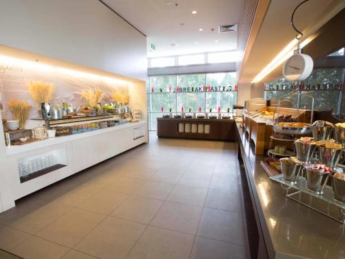 a restaurant with a counter with a buffet at ibis Sydney Olympic Park in Sydney