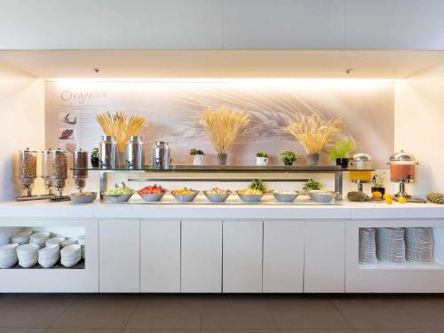 a buffet with bowls of food on a counter at ibis Sydney Olympic Park in Sydney