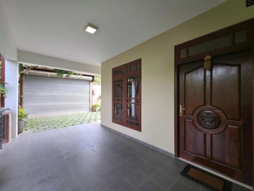 an empty hallway with a wooden door and a garage at Vithum Villa - Kandy Home with Balcony View and Parking in Kandy