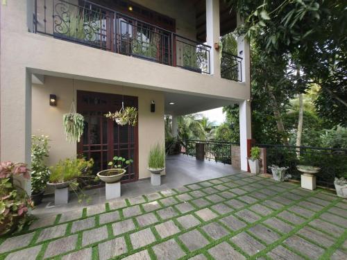 a porch of a house with potted plants and a balcony at Vithum Villa - Kandy Home with Balcony View and Parking in Kandy