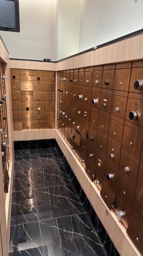 a locker room with brown lockers and a black floor at Axon Residence Pavilion Bukit Bintang SkyView in Kuala Lumpur