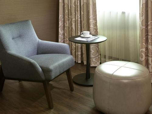 a chair and a stool with a cup on a table at Sofitel Philadelphia at Rittenhouse Square in Philadelphia