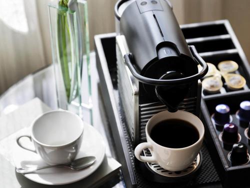 a coffee maker and two cups of coffee on a counter at Sofitel Philadelphia at Rittenhouse Square in Philadelphia