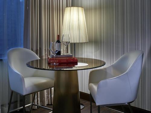 a table with two chairs and a lamp on it at Sofitel Philadelphia at Rittenhouse Square in Philadelphia