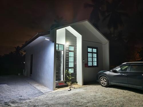 a car parked in front of a house at night at The Pesona Beach House in Bachok