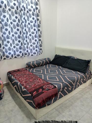 a bed in a room with a curtain and a bed with a bedskirtspects at The Pesona Beach House in Bachok
