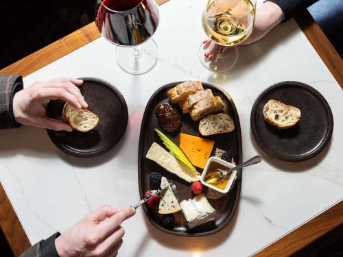 a table with two plates of food and glasses of wine at Sofitel Philadelphia at Rittenhouse Square in Philadelphia