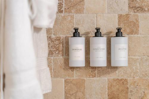 tres botellas de odorizantes en una pared en un baño en Oceanfront Bliss Cozy 1BR by Beach Free Parking, en Hollywood
