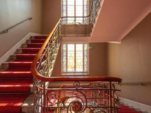 a spiral staircase with red carpet and stained glass windows at ibis Lyon Centre Perrache in Lyon