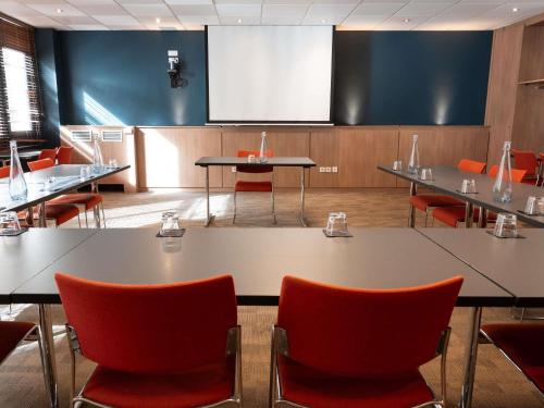 a conference room with tables and chairs and a screen at ibis Lyon Centre Perrache in Lyon