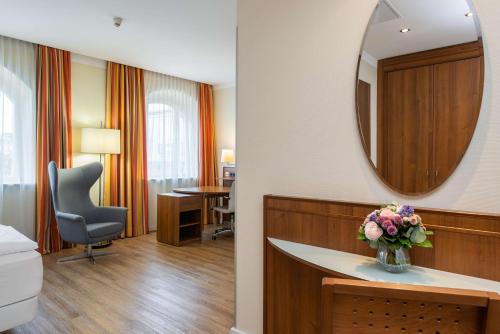 a hotel room with a vanity and a mirror at NH Wien Belvedere in Vienna