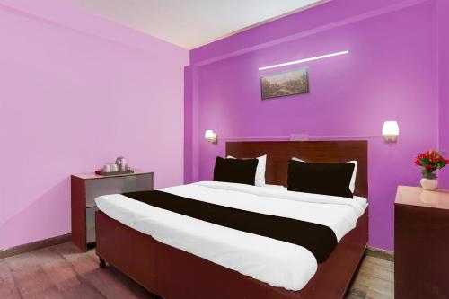 a bedroom with a large bed with purple walls at Hotel O Green Park Residency 2 in New Delhi