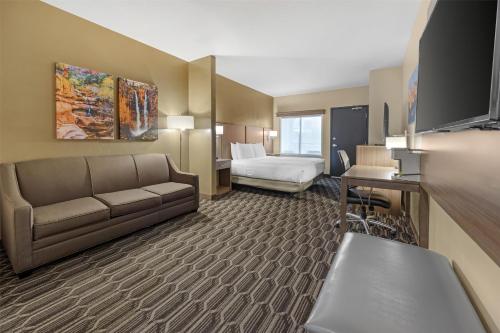 a hotel room with a couch and a bed at Best Western Plus Zion Canyon Inn & Suites in Springdale