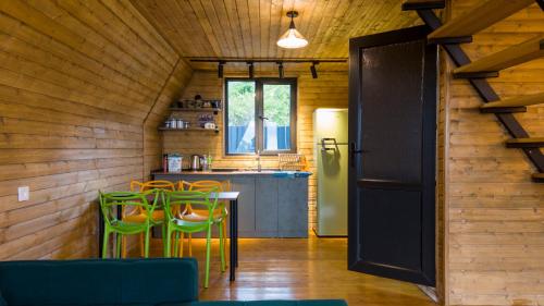 Una cocina con mesa y sillas y un refrigerador. en Sagarejo Wood House, 