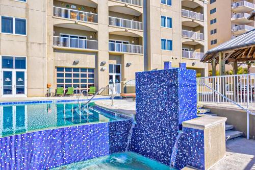 a swimming pool with a fountain in front of a building at Escapes to the Shores 1101 in Orange Beach