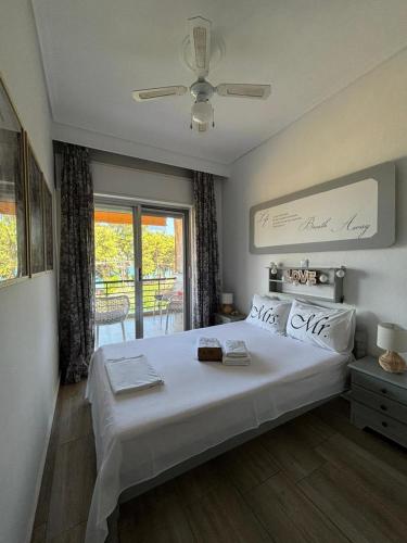 a bedroom with a large white bed and a window at Nisteri Seaside in Limenas