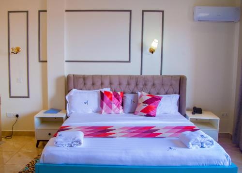 a bedroom with a large bed with colorful pillows at cyro reservations in Nalakonge
