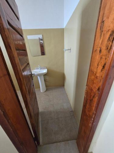 a bathroom with a sink and a toilet and a door at Hillview Guest House 