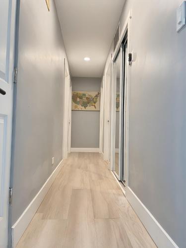an empty hallway with white walls and wooden floors at Comfort Meets Convenience in Schaumburg