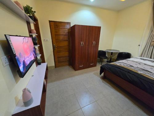 a bedroom with a bed and a dresser and a television at Hillview Guest House 
